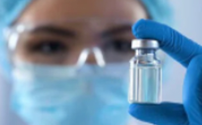 Contract Testing, Development & Manufacturing Services Female manufacturing engineer holding ampule of a novel therapeutic.