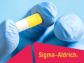 Close-up of gloved hands handling a yellow-and-white laboratory sample tube, with “Sigma-Aldrich” branding visible on a red label in the foreground.